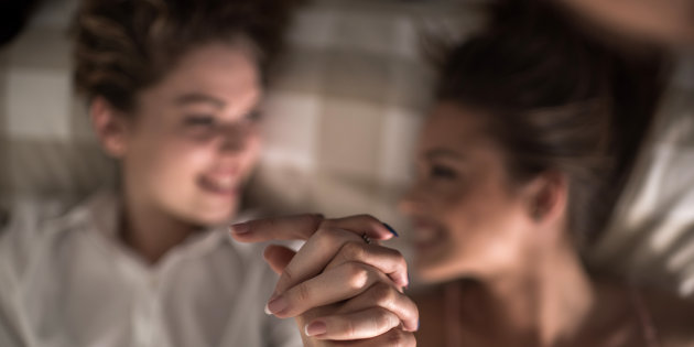 Close up of two female friends holding hands.